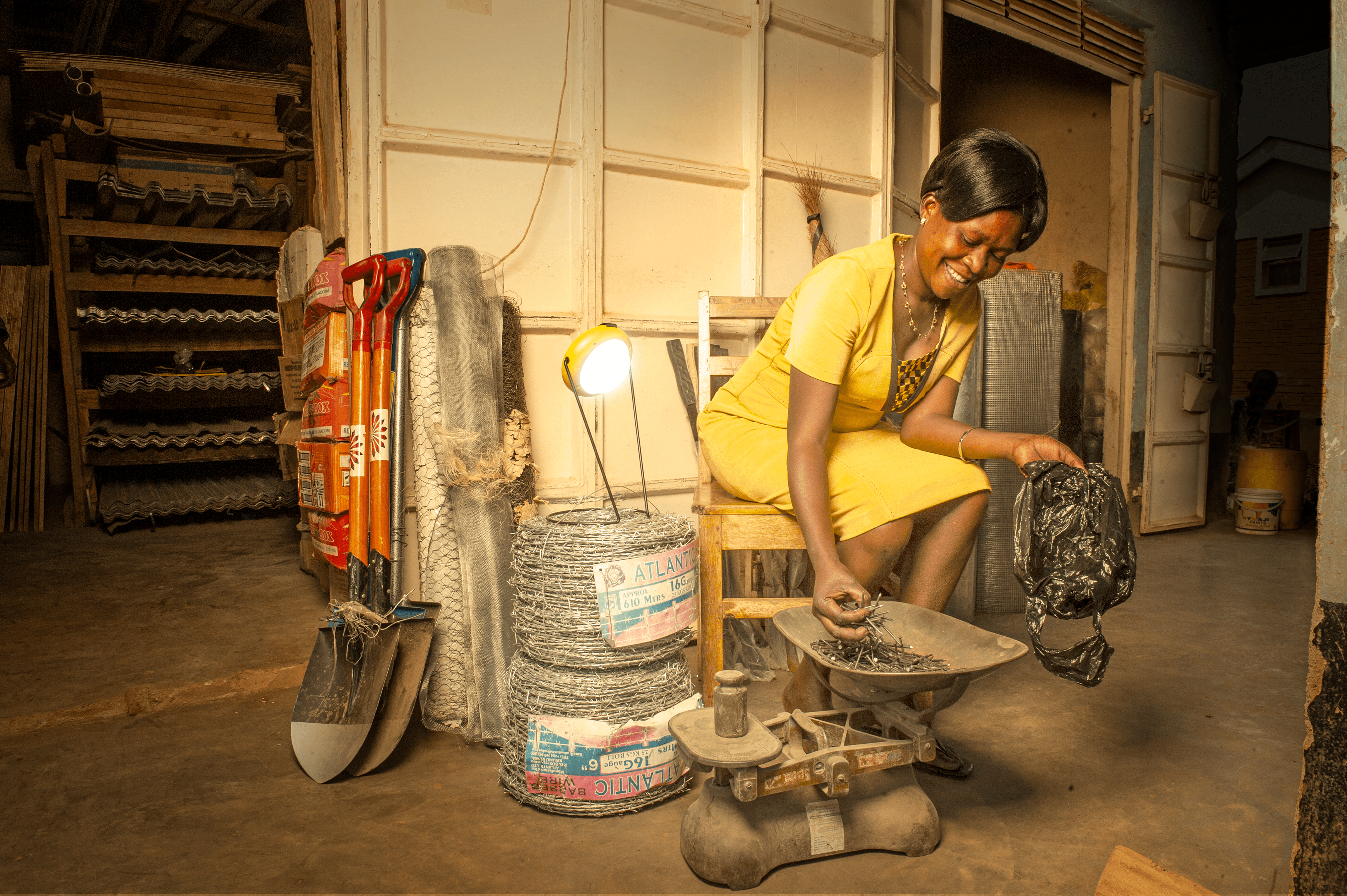 A woman uses the Sun King Pro 200 portable solar powered lantern to light up her space as she works.